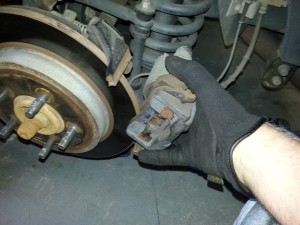 Tip the top of the caliper out first, then the bottom.  This will be reversed for installing after pads are replaced.